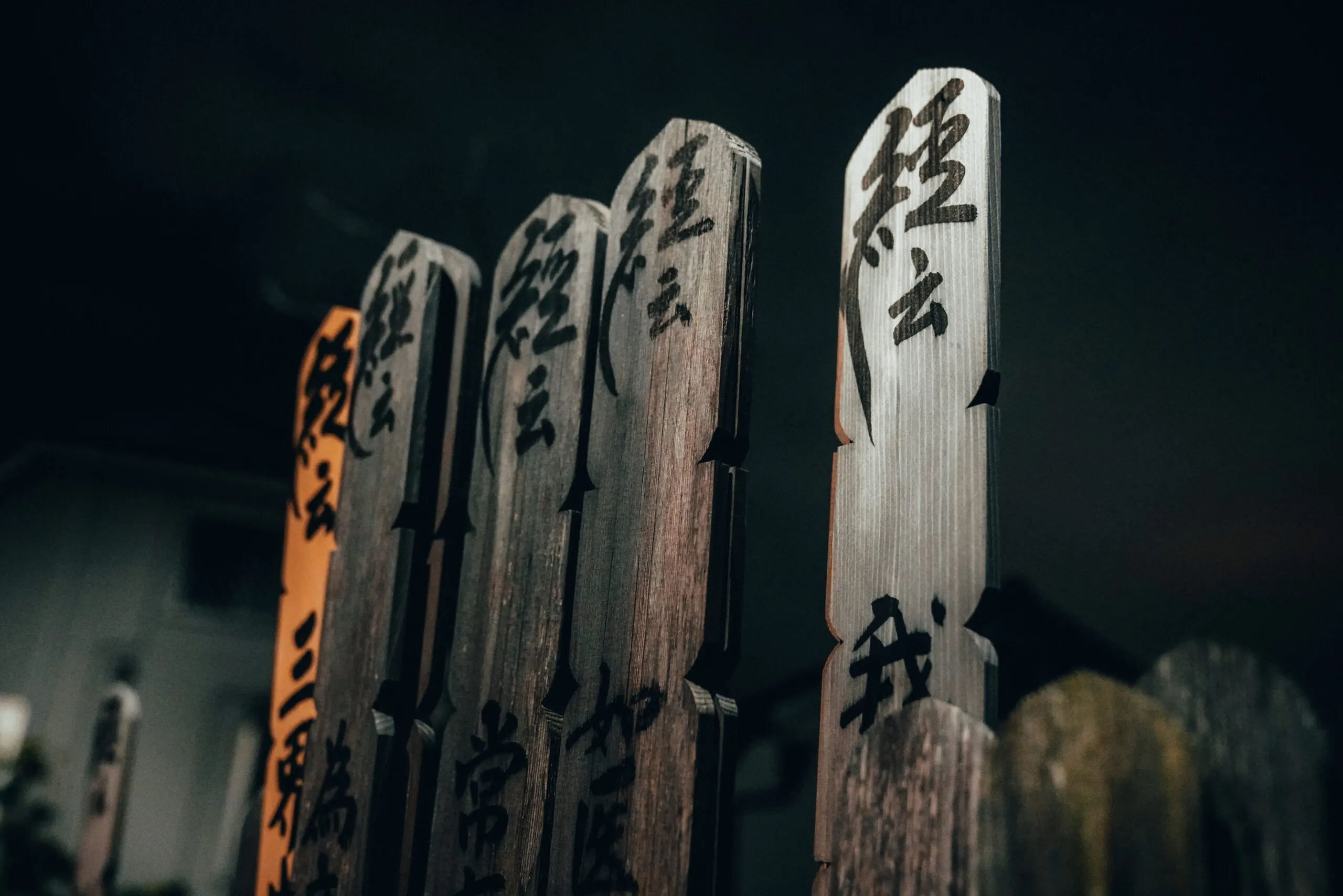 Wooden memorial tablets with Japanese characters at night