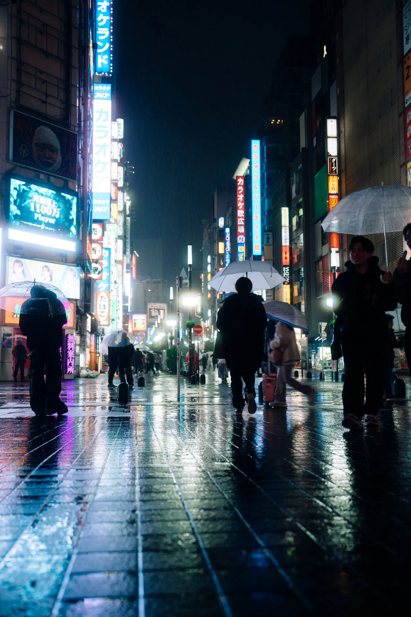 Rainy Tokyo street at night with neon signs and umbrellas